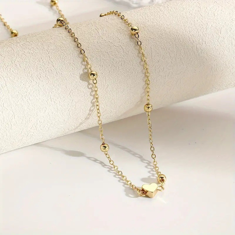 Sierlijke gouden hartvormige t - Body Jewellery recensie en prijs